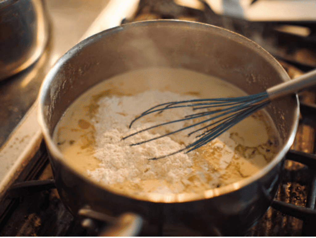 whisking flour into melted butter to create roux for chicken and wild rice soup recipe