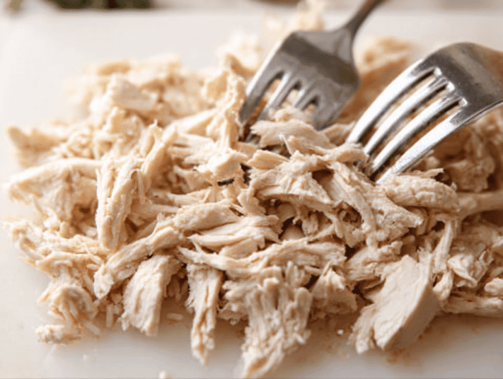 shredded chicken on cutting board for chicken and wild rice soup recipe