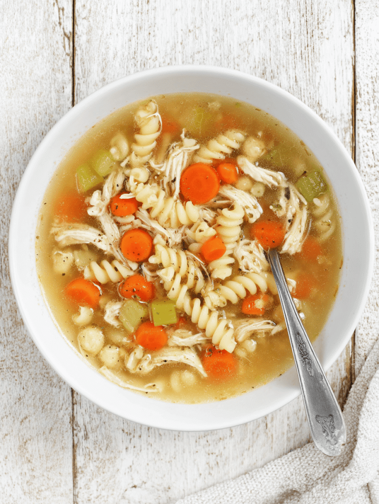 High Protein Chicken Noodle Soup – The Ultimate Cozy 30-Minute Meal 9 Bowl of High Protein Chicken Noodle Soup with chickpea pasta, chicken, carrots, and celery.