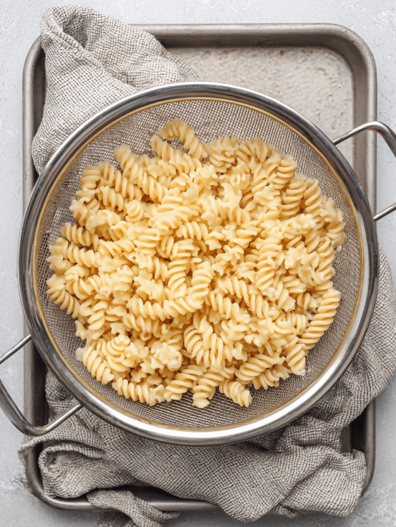 High Protein Chicken Noodle Soup – The Ultimate Cozy 30-Minute Meal 5 Drained chickpea pasta in a colander for High Protein Chicken Noodle Soup.