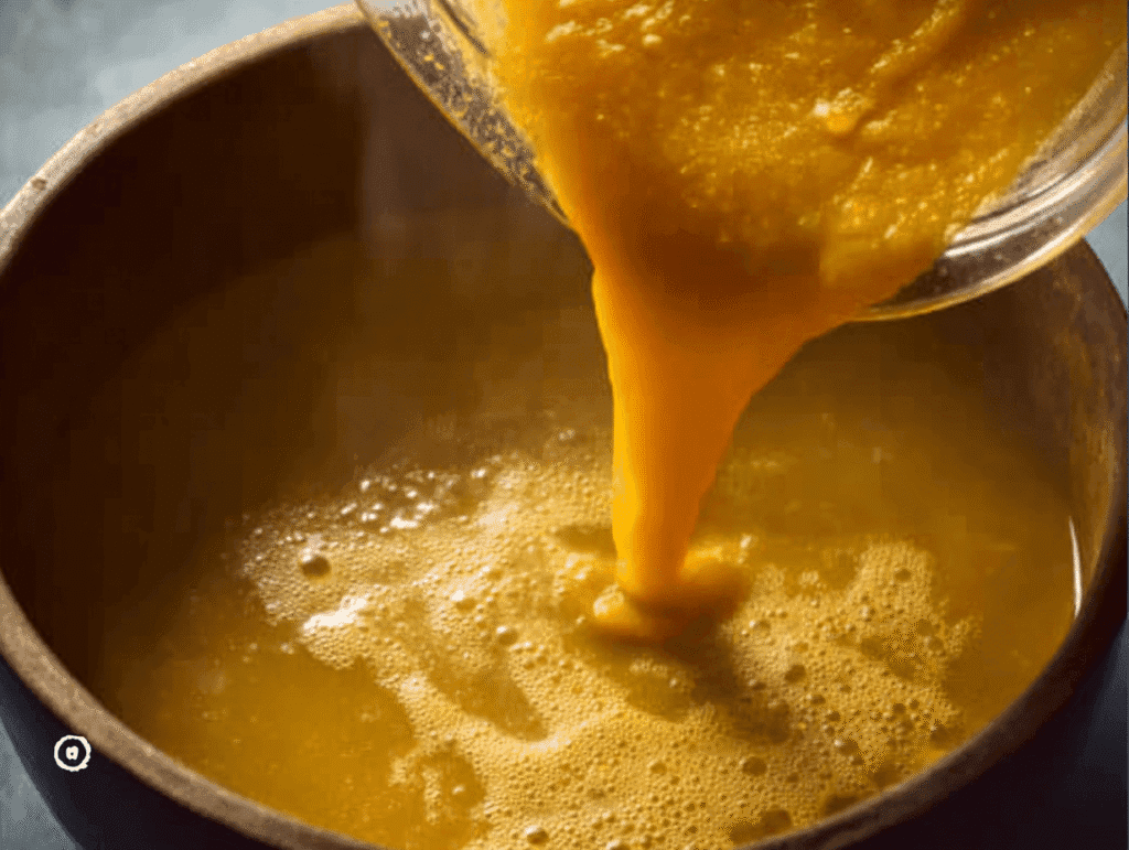 Pouring blended vegetable puree into chicken broth for Italian Penicillin Soup Recipe