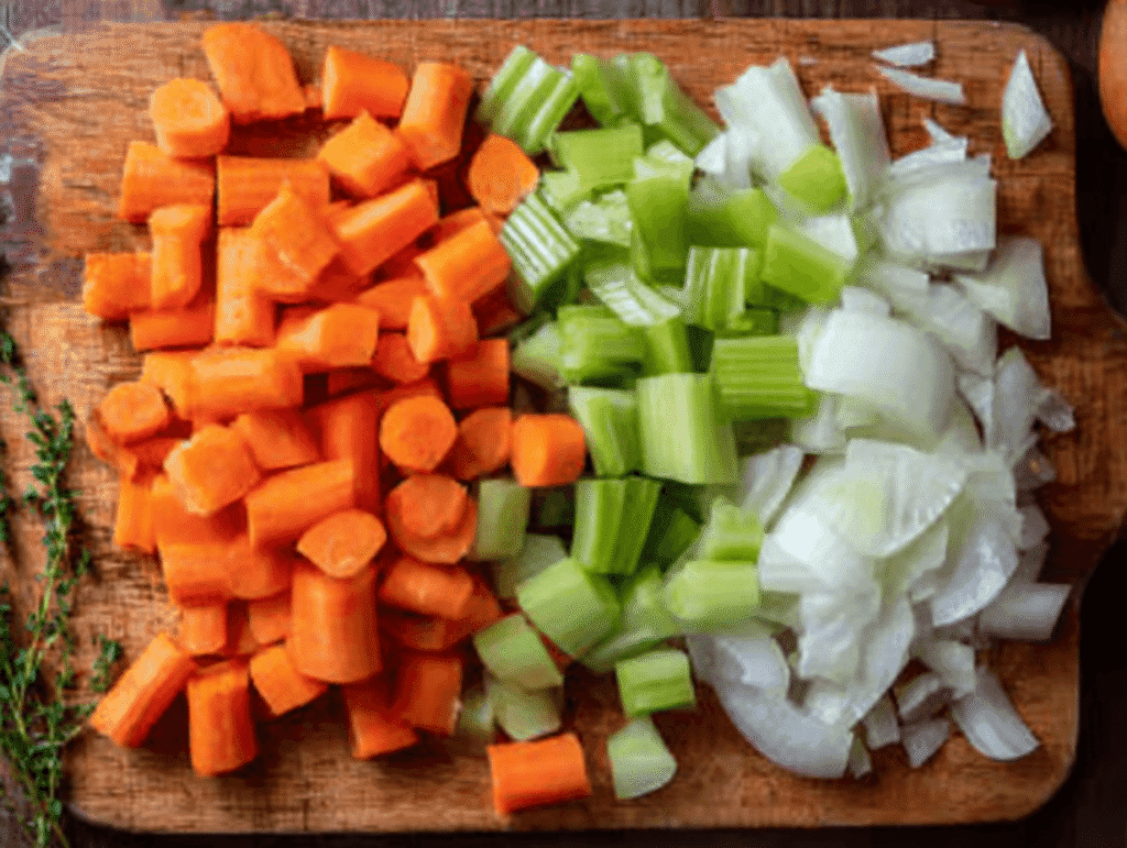 Chopped carrots, celery, and onions on a cutting board for Italian Penicillin Soup Recipe