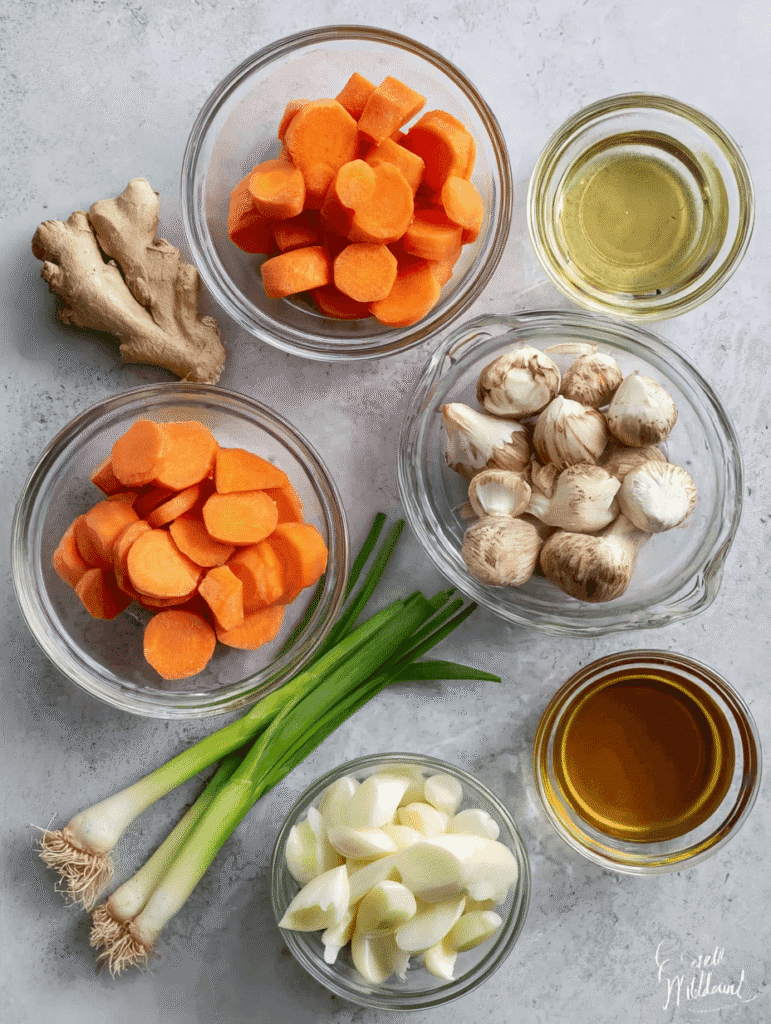 Fresh ingredients for Japanese clear soup including mushrooms, carrots, onions, garlic, ginger, and broth