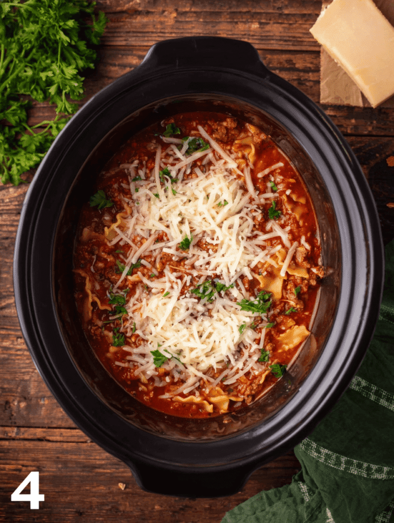 Lasagna soup crockpot step 4 topped with melted mozzarella and parmesan cheese