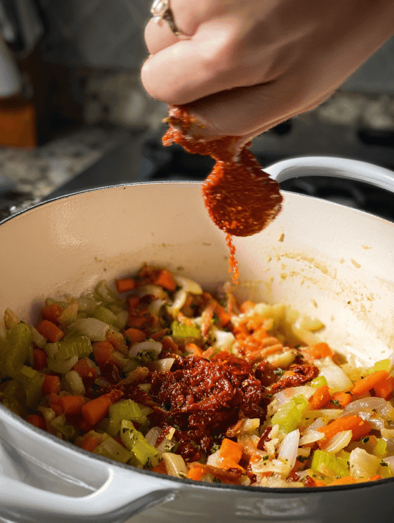 Adding tomato paste to sautéed vegetables for Marry Me Chicken Gnocchi Soup