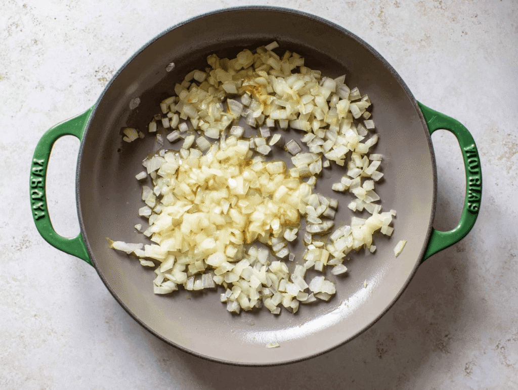 Diced onions sautéing in skillet for Crockpot Potato Soup recipe step