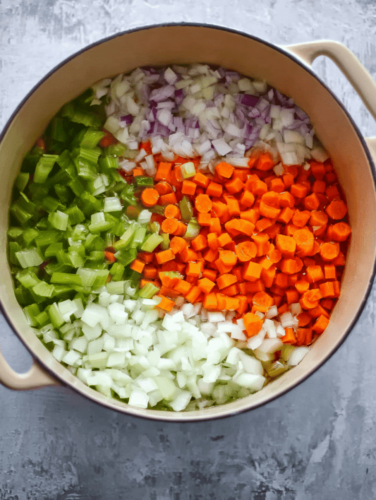 Chopped onions, celery, and carrots in a pot ready for soup base