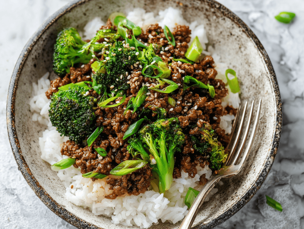ground beef and broccoli stir fry over rice in ceramic bowl